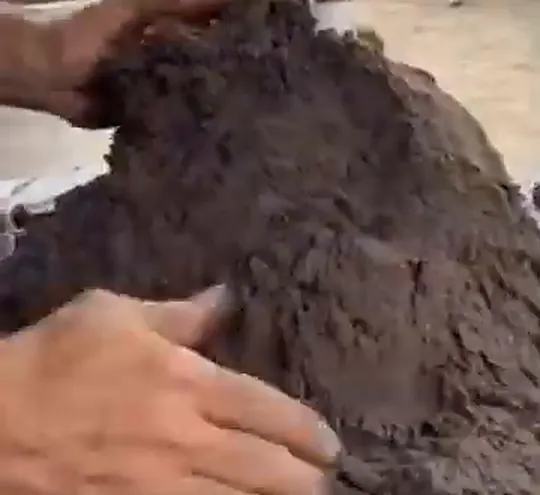 Mãos modelando o monte de areia
